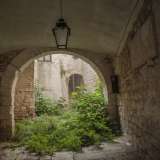 Ad accoglierci un ingresso abbellito da un lampadario in ferro battuto che, attraverso un arco a tutto sesto...